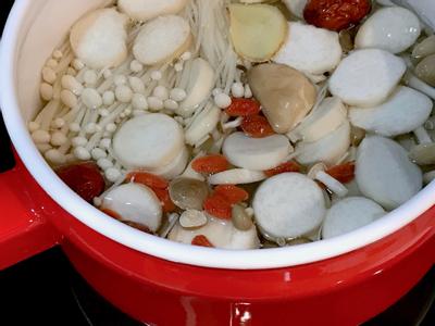 取一湯鍋加入適量的水，直接加入菇類及除了豬肉及蔥的所有配料，中火將水煮開。