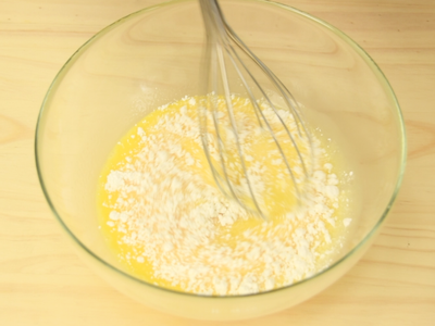 待牛奶液降至手溫後（約40~50度即可），加入蛋黃液攪拌均勻。再分2~3次加入麵粉攪拌至看不到麵粉。